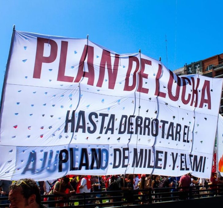 White banner with red and black lettering from the general strike, reading: “A plan for struggle until the defeat of Milei and the IMFs Plan.”