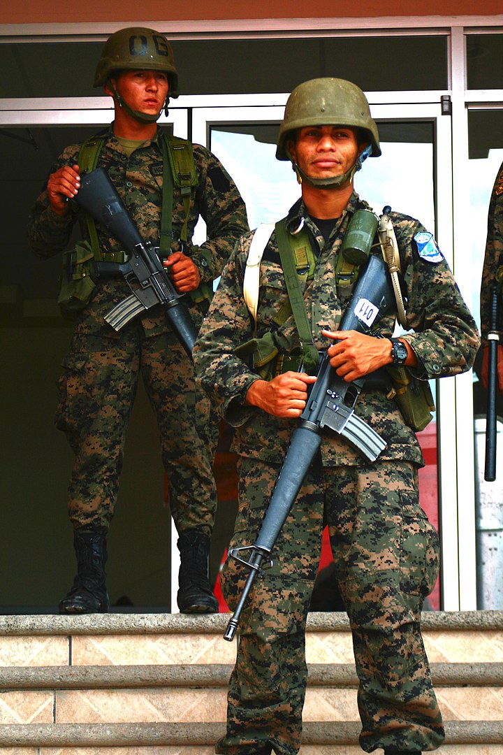 Two Honduran soldiers with automatic weapons, securing a location during the 2009 Honduran coup d’etat.