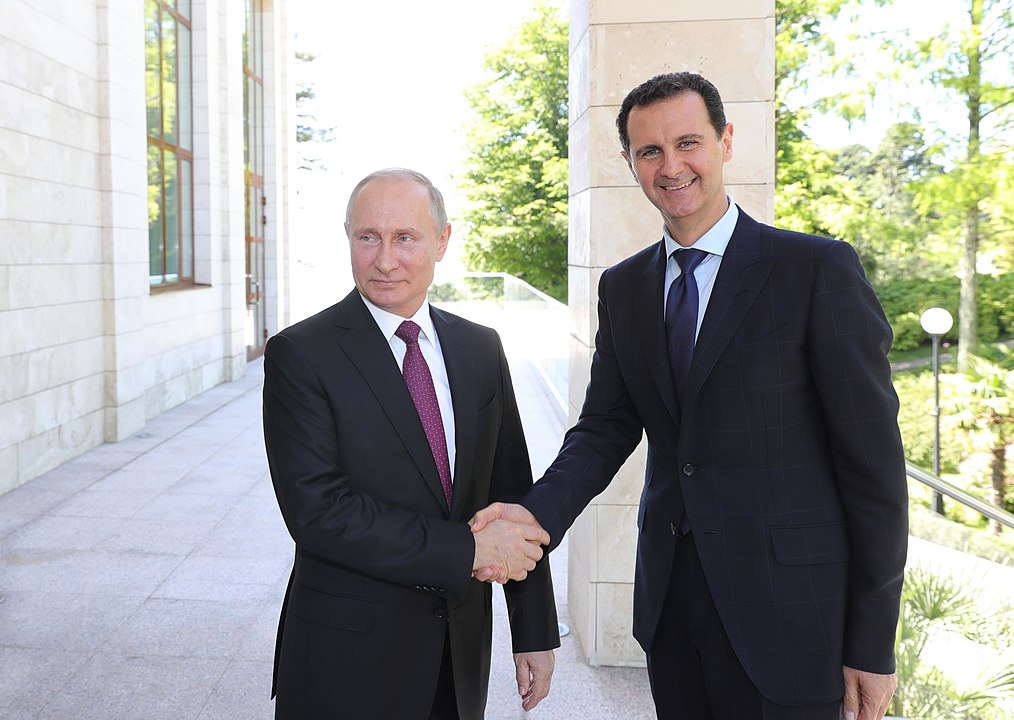 Vladimir Putin and Bashar al-Assad shaking hands in Moscow during a state visit in May 2018. 