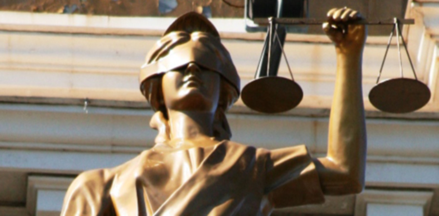An image of a statue of justice as a woman, holding scales and wearing a blindfold.