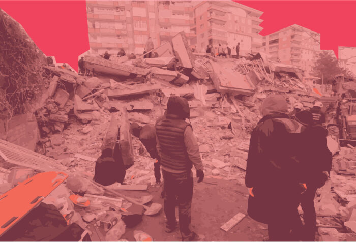 People stand witnessing the rubble of a building destroyed by the earthquake.