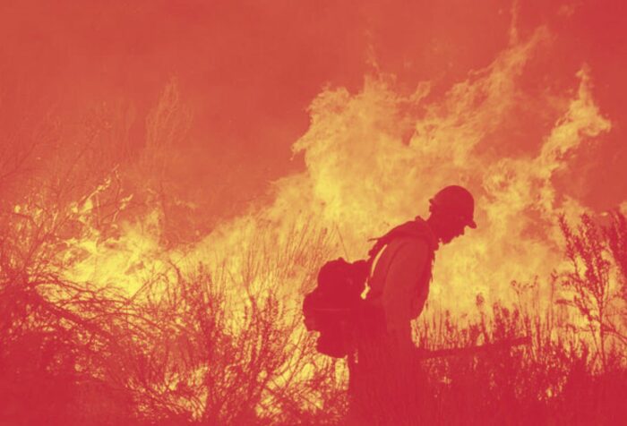 a firefighter in front of a blazing fire
