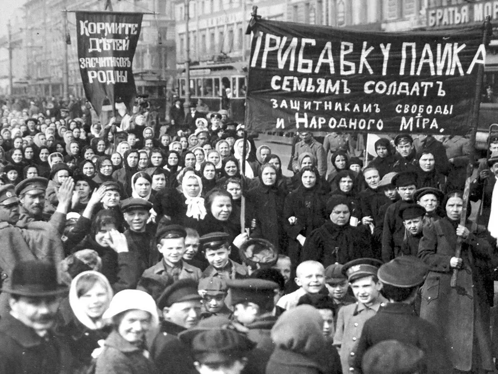 a crowd of women in a black and white photo hold signs in russian.