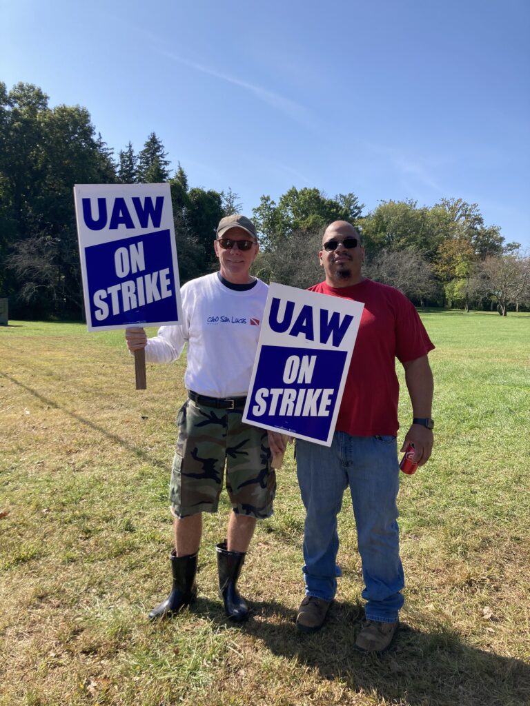 two men holding UAW strike signs