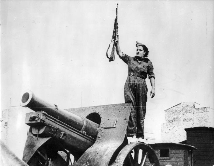 Woman standing on top of a cannon with her rifle in the air. Spanish Civil War. Barcelona, 1936. Photo by Nationaal Archief.