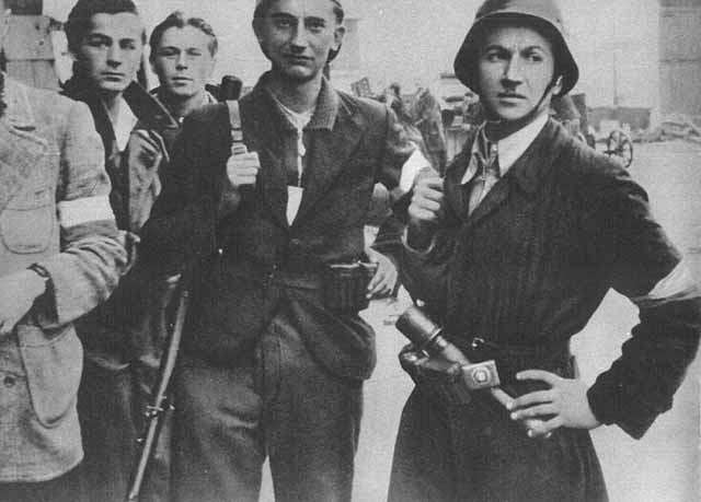 Five soldiers carrying guns in a black and white photograph. They look sober but determined.