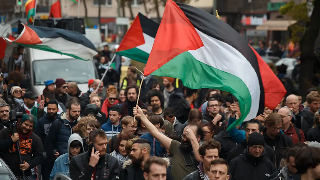 Multiracial image of protesters at a November 2023 demonstration for Palestine, London, United Kingdom. Multiple protesters are carrying large, oversized Palestinian flags.