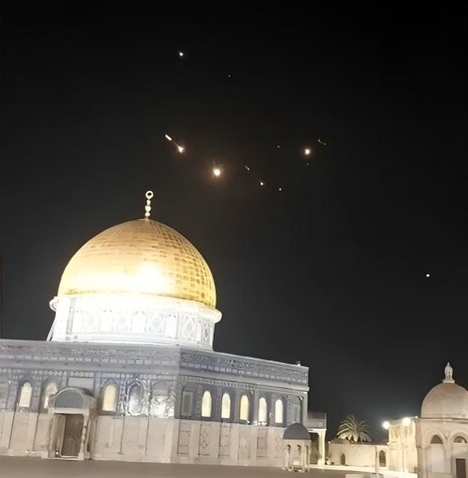 missiles are small lights in the night sky above a gold-domed building.