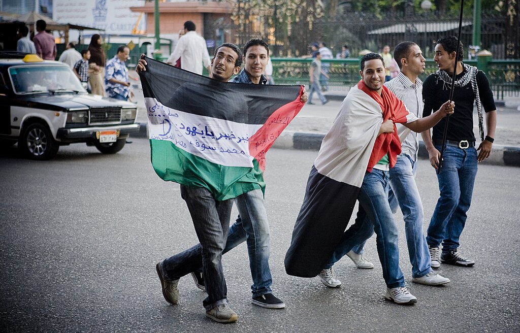  Thousands of Egyptian protesters rallied against religious sectarianism and in solidarity with the Palestinian intifada, in Tahrir Square on Friday May 13th 2011. The photo shows five protestors, one of them marching with Palestinian flag and one with the flag draped over his shoulder. Photo by: Hossam el-Hamalawy حسام الحملاوي.